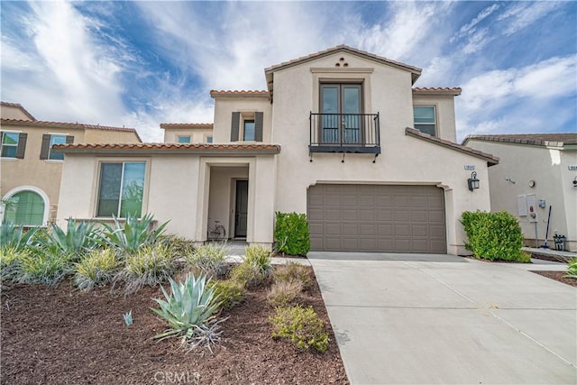 mediterranean / spanish-style house with driveway, a garage, stucco siding, and a balcony