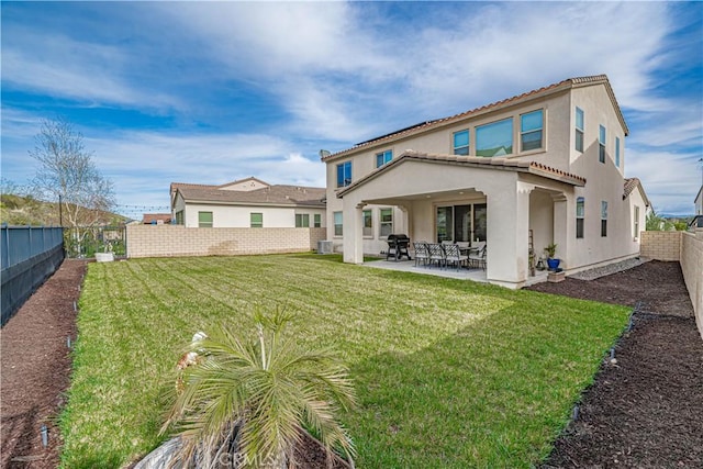 rear view of house featuring a patio, a fenced backyard, stucco siding, and a yard