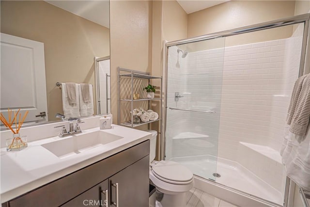 bathroom featuring toilet, a shower stall, and vanity