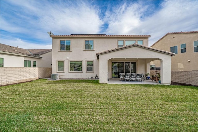 back of house featuring a lawn, fence, stucco siding, and a patio area
