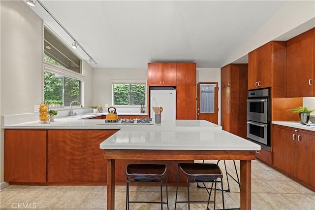 527 Bradford St, Pasadena, CA 91105 - kitchen featuring stainless steel double oven, refrigerator, light countertops, a peninsula, and white gas cooktop
