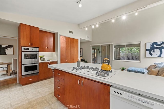 527 Bradford St, Pasadena, CA 91105 - kitchen with brown cabinets, track lighting, white appliances, light countertops, and open floor plan