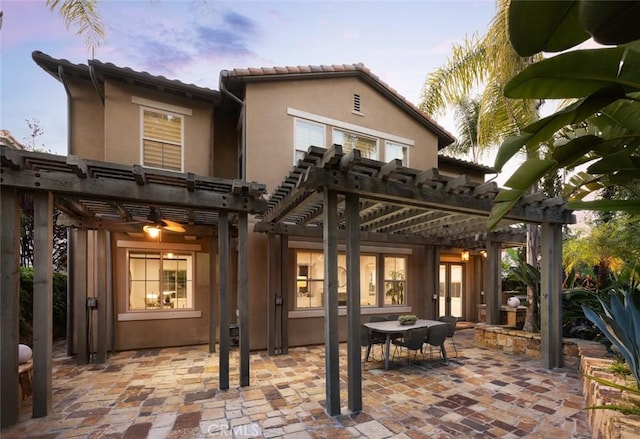26 Via Fontibre, San Clemente, CA 92673 - back of property at dusk with a pergola, stucco siding, a patio area, and outdoor dining area