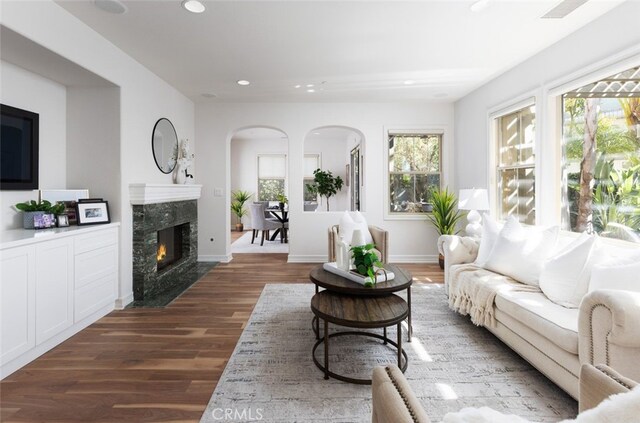 26 Via Fontibre, San Clemente, CA 92673 - living room featuring arched walkways, wood finished floors, recessed lighting, a fireplace, and healthy amount of natural light