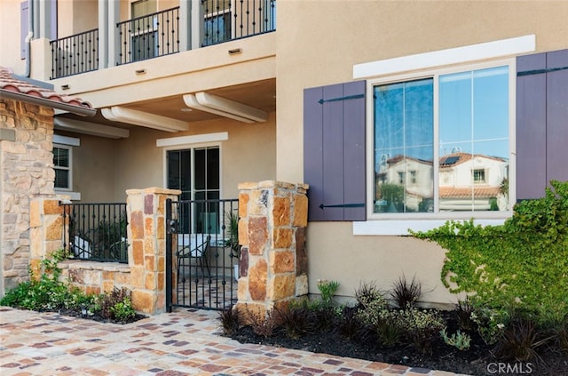 26 Via Fontibre, San Clemente, CA 92673 - property entrance with stone siding, stucco siding, a balcony, and a gate