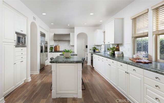 26 Via Fontibre, San Clemente, CA 92673 - kitchen with built in appliances, arched walkways, white cabinets, backsplash, and recessed lighting