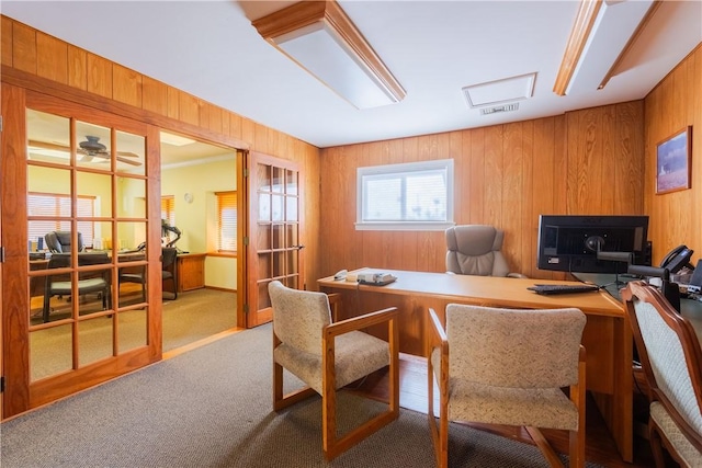 office featuring carpet, wooden walls, and visible vents