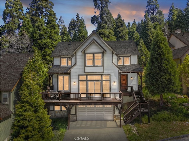 view of front of house featuring stairway, roof with shingles, concrete driveway, and a garage