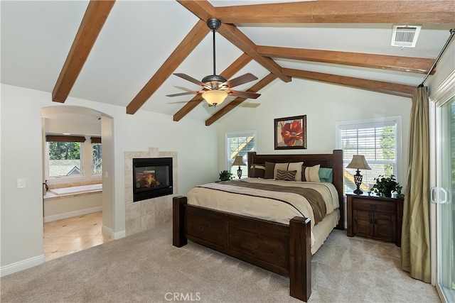 455 Clearwater Ln, Lake Arrowhead, CA 92352 - bedroom with light carpet, a tiled fireplace, arched walkways, light tile patterned flooring, and ceiling fan
