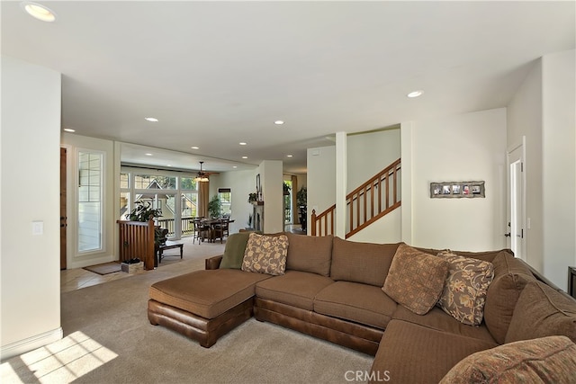 carpeted living room with recessed lighting and stairs