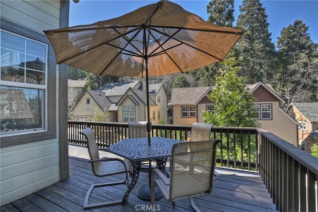 wooden terrace featuring a residential view and outdoor dining area