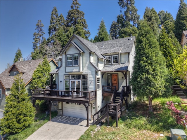 view of front of house featuring driveway, stairs, a shingled roof, covered porch, and a garage