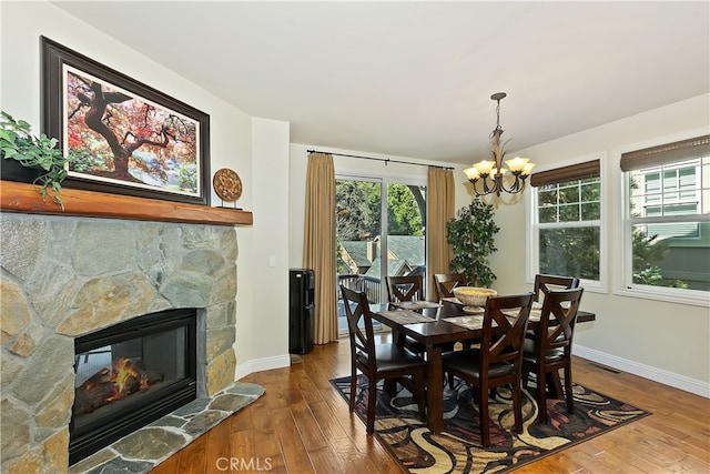 dining room with baseboards, visible vents, a notable chandelier, and wood-type flooring