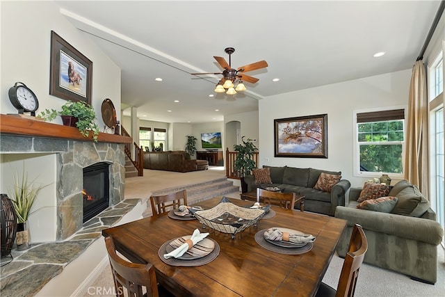 dining room with a stone fireplace, recessed lighting, carpet flooring, and ceiling fan