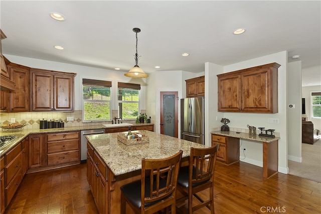 kitchen with recessed lighting, a sink, stainless steel appliances, dark wood-type flooring, and a center island