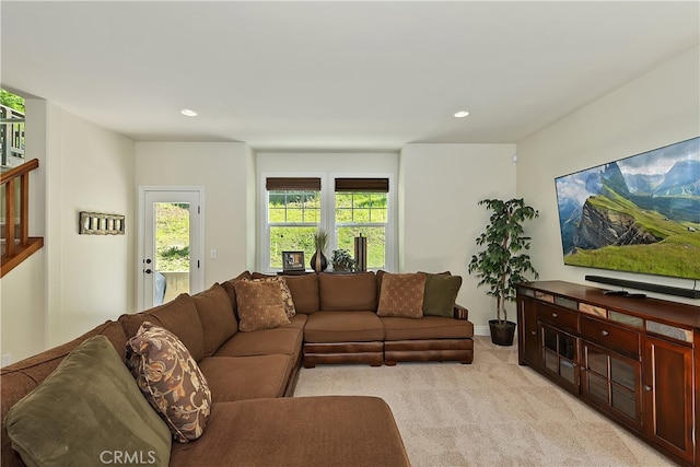 living room featuring recessed lighting, stairway, and light colored carpet