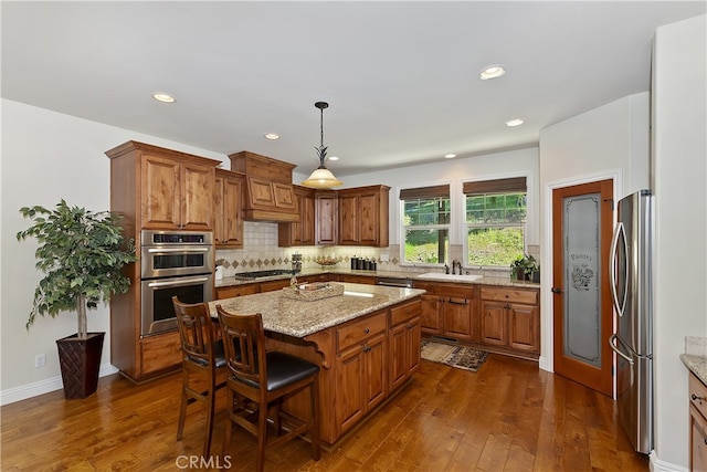 kitchen featuring custom exhaust hood, dark wood-style floors, a sink, and stainless steel appliances