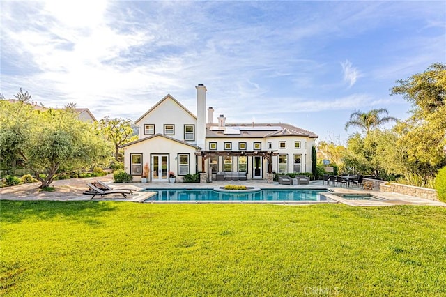 rear view of property with french doors, an outdoor pool, an in ground hot tub, and a patio area