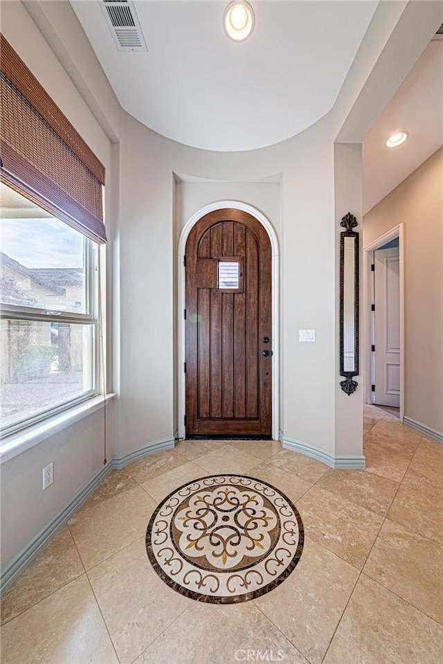entryway with recessed lighting, arched walkways, visible vents, and baseboards