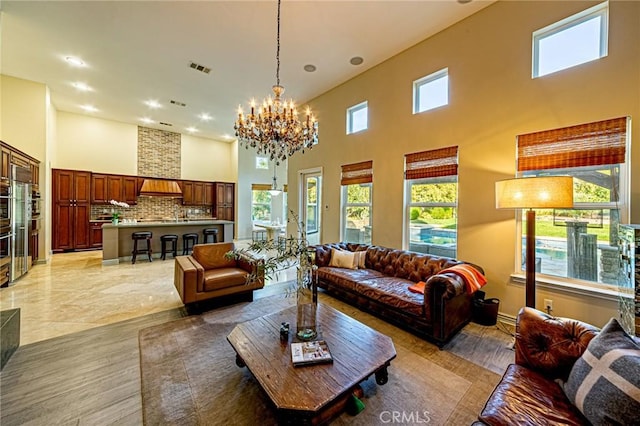 living room featuring a chandelier, recessed lighting, and a towering ceiling