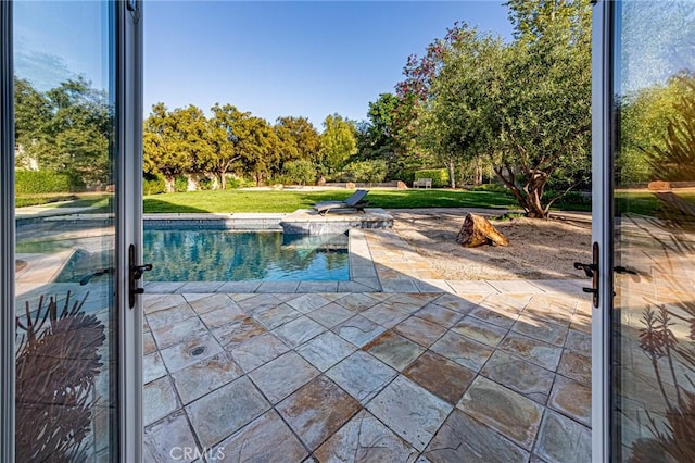 outdoor pool featuring a patio and a lawn