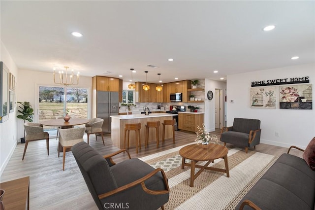 living area with recessed lighting, a chandelier, light wood finished floors, baseboards, and visible vents