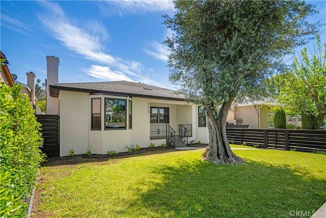 4926 Templeton St, Los Angeles, CA 90032 - back of house featuring a lawn, stucco siding, and fence
