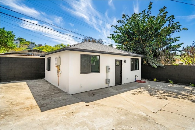 4926 Templeton St, Los Angeles, CA 90032 - view of front of house with a shingled roof, a fenced backyard, stucco siding, and a patio area