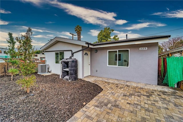 ranch-style house featuring a patio area, central AC unit, stucco siding, and fence