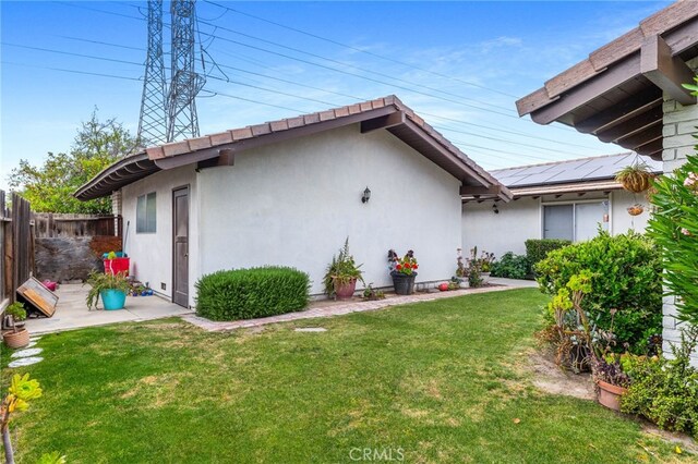 3406 Elm St, Bakersfield, CA 93301 - exterior space featuring fence, solar panels, stucco siding, and a yard