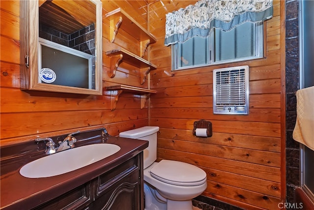 bathroom with toilet, wooden walls, and vanity
