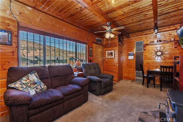 living room featuring beamed ceiling, ceiling fan, wood walls, carpet, and wood ceiling