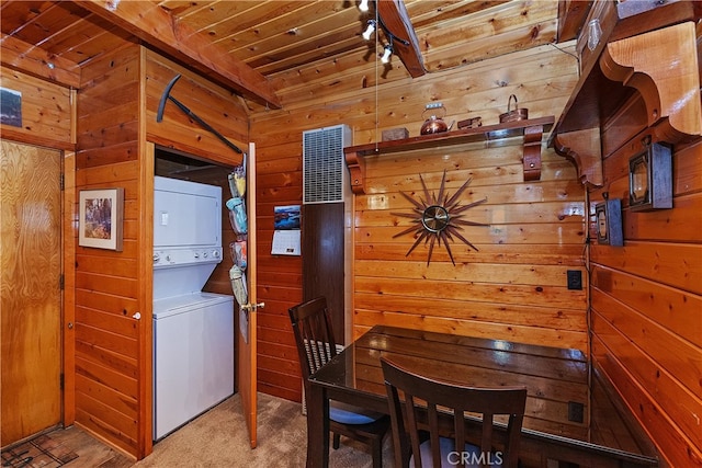 laundry room featuring stacked washer and dryer, carpet floors, laundry area, wood ceiling, and wooden walls