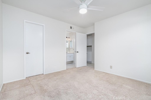 unfurnished bedroom featuring visible vents, baseboards, ensuite bath, and light carpet