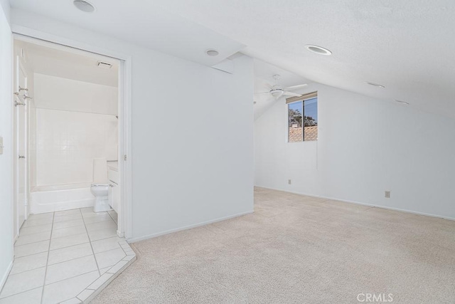 additional living space featuring ceiling fan, light carpet, lofted ceiling, and baseboards