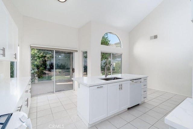 kitchen featuring visible vents, light tile patterned floors, a sink, and white dishwasher