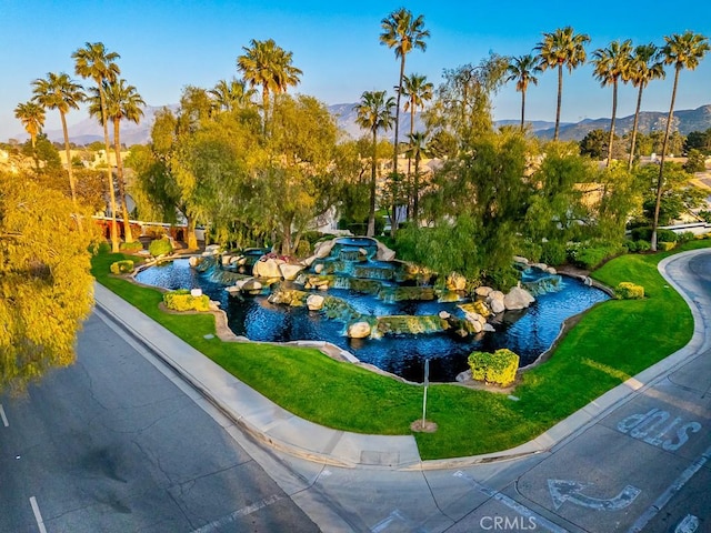 surrounding community featuring a small pond and a mountain view