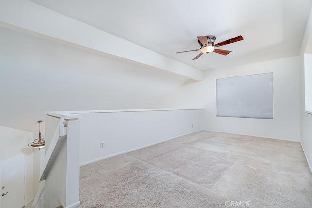 empty room with lofted ceiling with beams, a ceiling fan, baseboards, and carpet floors