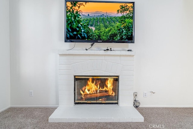interior details with a brick fireplace, carpet, and baseboards