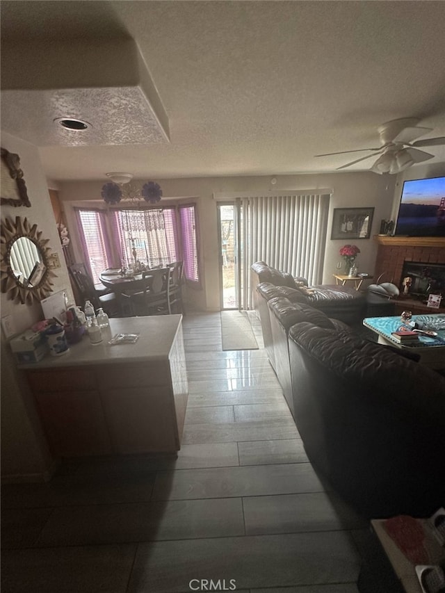 living room featuring ceiling fan and a textured ceiling