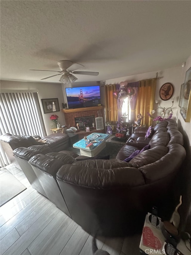 living area featuring ceiling fan, a textured ceiling, and plenty of natural light