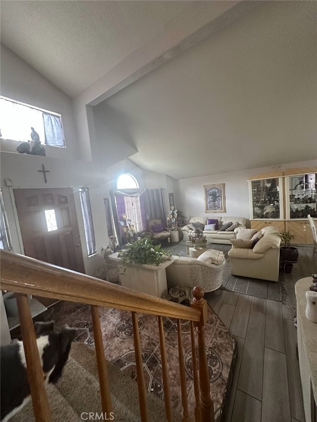 living room with wood finished floors and vaulted ceiling