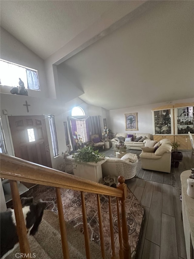 living area with wood finished floors and lofted ceiling