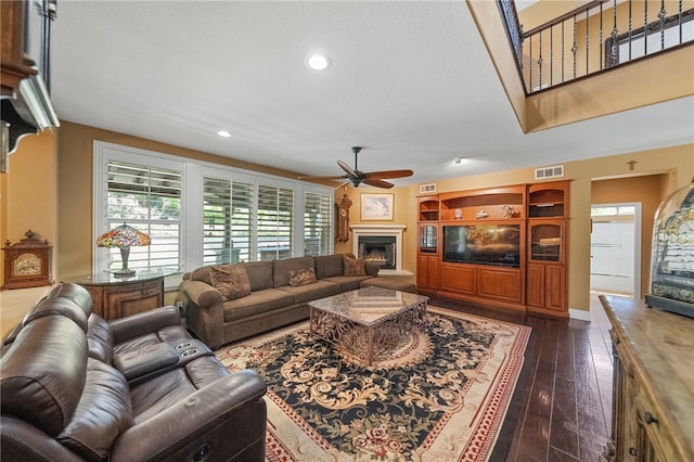 33931 Baystone St, Temecula, CA 92592 - living area with ceiling fan, a lit fireplace, dark wood-type flooring, and recessed lighting