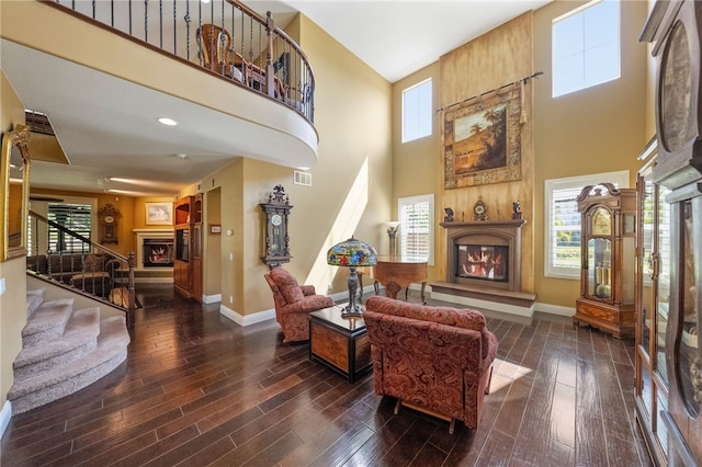 33931 Baystone St, Temecula, CA 92592 - living room featuring a glass covered fireplace, stairway, a towering ceiling, and baseboards