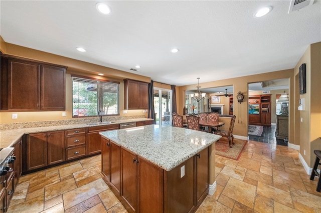 33931 Baystone St, Temecula, CA 92592 - kitchen featuring stone tile flooring, a kitchen island, a chandelier, stainless steel dishwasher, and light stone counters