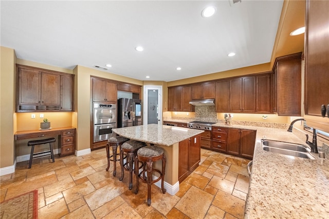33931 Baystone St, Temecula, CA 92592 - kitchen featuring under cabinet range hood, a sink, a kitchen island, appliances with stainless steel finishes, and stone tile flooring