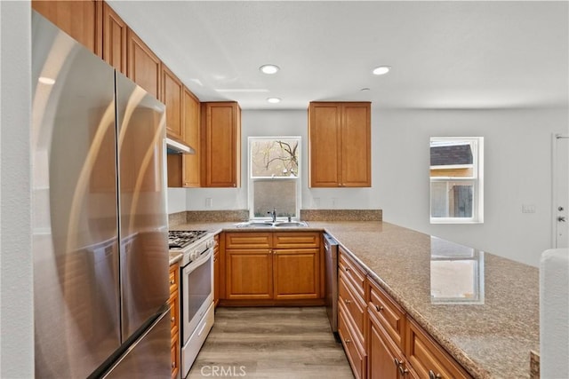 26145 Gravett Pl, Saugus, CA 91350 - kitchen with brown cabinetry, stainless steel appliances, light wood finished floors, and a sink