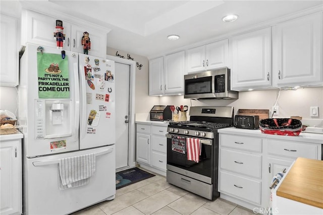 kitchen featuring recessed lighting, stainless steel appliances, light tile patterned flooring, white cabinetry, and light countertops