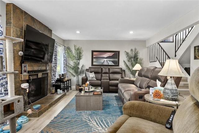 living area with recessed lighting, stairway, wood finished floors, and a fireplace